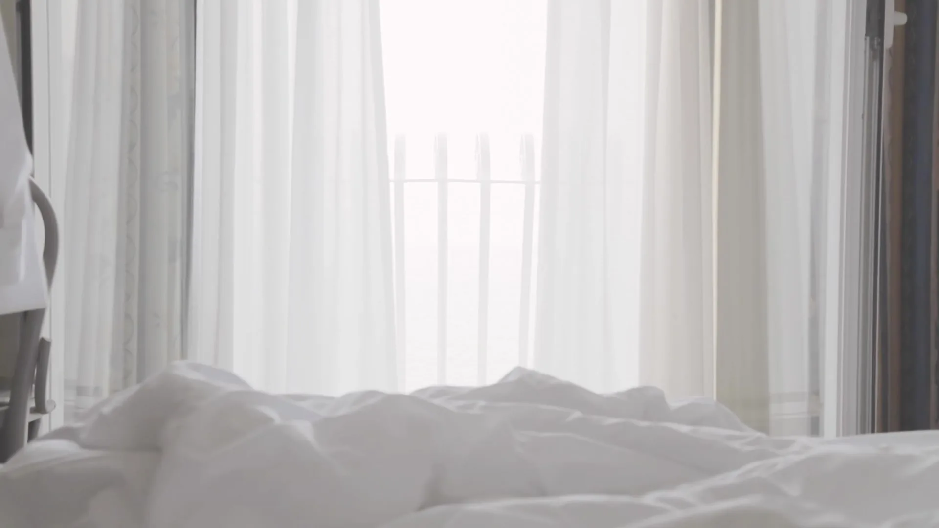 Sheer curtains filtering daylight in a bedroom